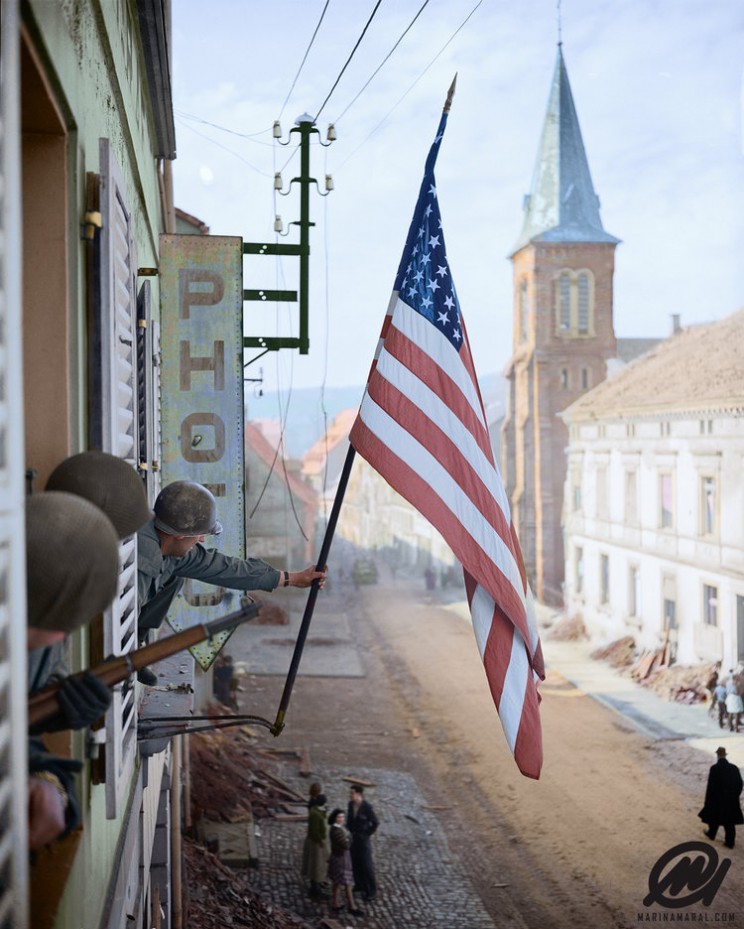 aptain Thomas H. Garahan, 'Easy' Company, 2nd Battalion, 398th Infantry Regiment, 100th Infantry Division Raises The 'Stars And Stripes' Flag Made Secretly By A Local French Girl.