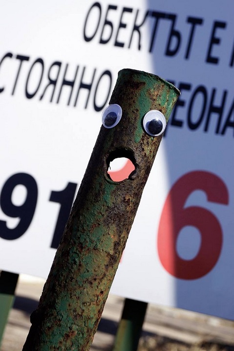 Corroded street post with googly eyes