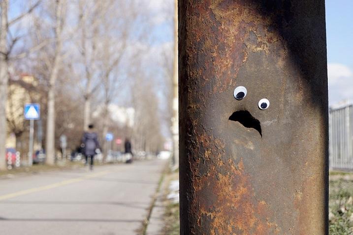 Corroding street post with googly eyes