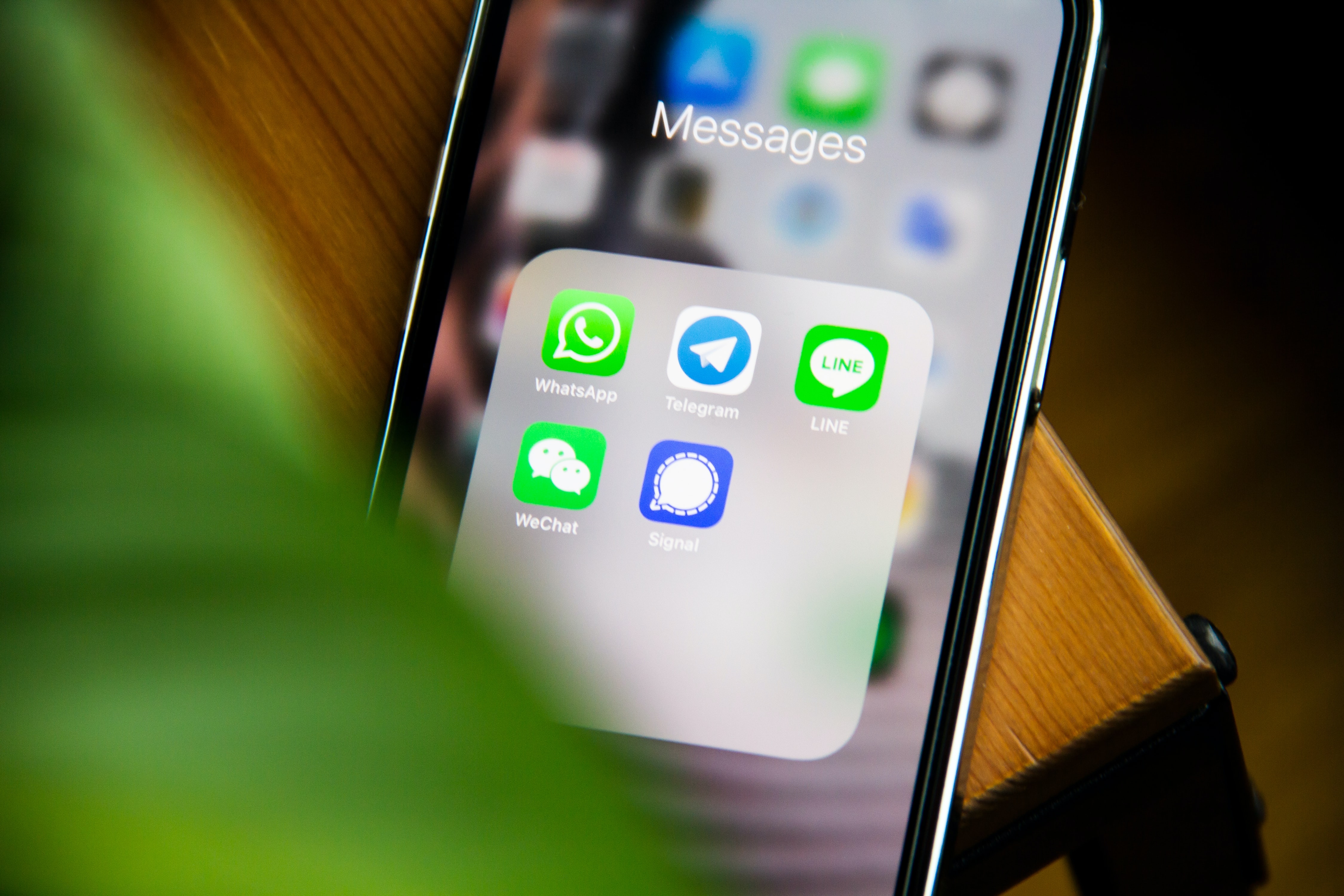 Various messaging app icons are displayed on a smartphone.