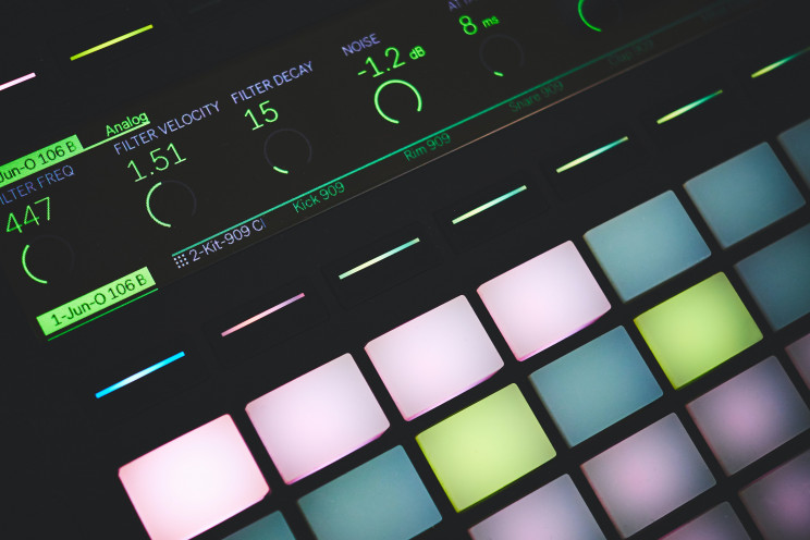 A music production center (MPC) with buttons for sampling and sequencing whose buttons are lit up in the dark.