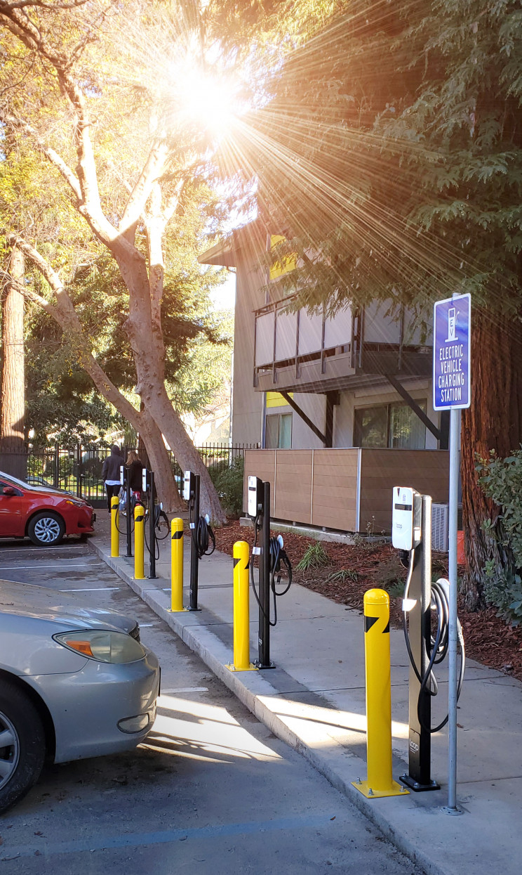A row of Loop's EV-Flex chargers sit in a parking lot.