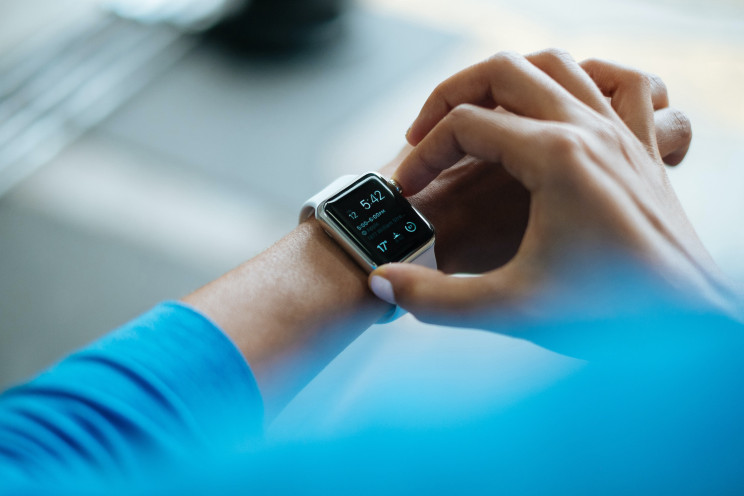 A person wearing a blue shirt operates their Apple Watch.